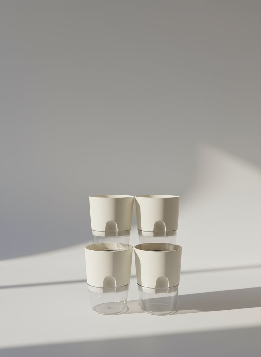 a set of four three-inch self-watering plant pots. White plastic with a clear bottom