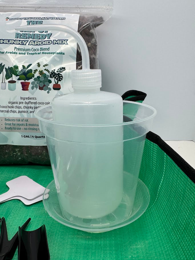 Clear plastic container with a white pump on a green surface, with a bag of potting mix in the background.