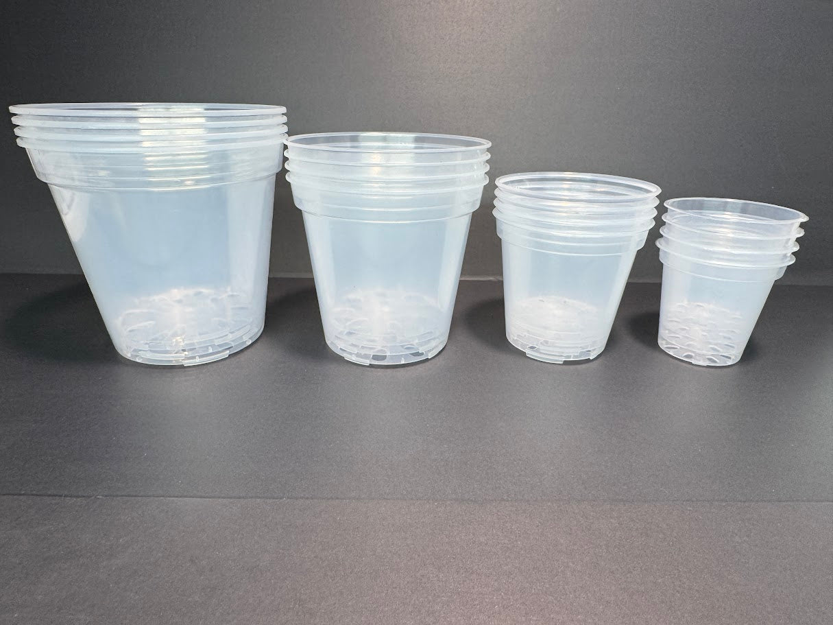Set of clear plastic nursery pots of different sizes on a gray background