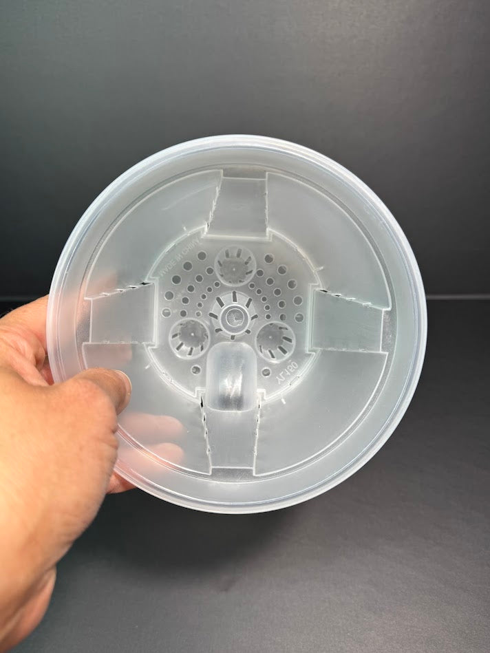 A hand holding a 6inch self watering pot, showing the inside detail