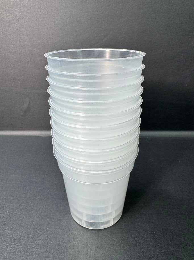 A stack of clear plastic cups with ridged sides, photographed against a dark gray background.