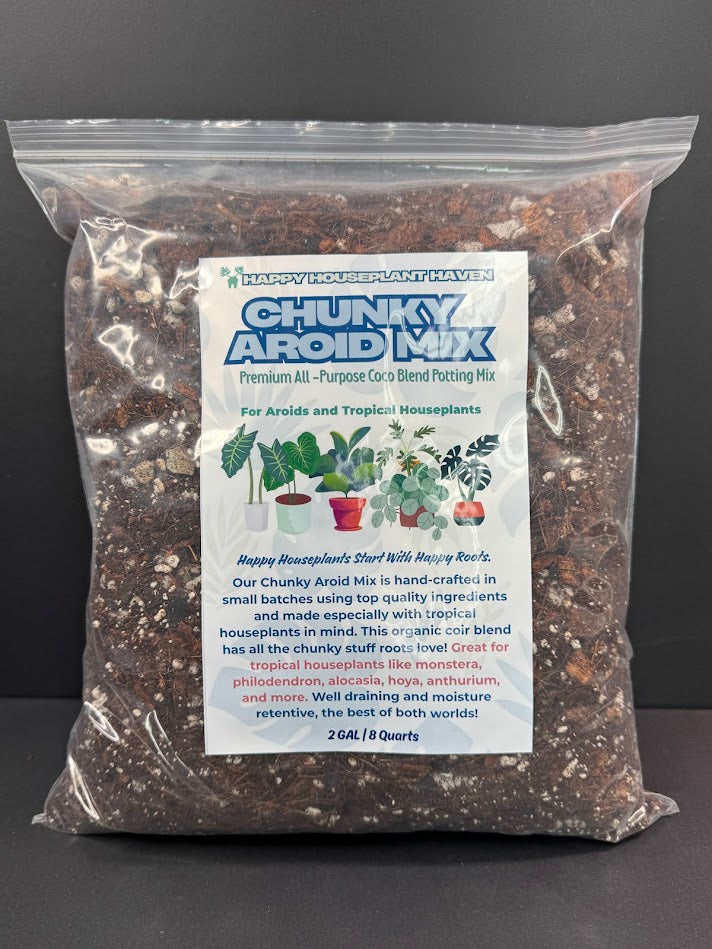 A 2GAL bag of Happy Houseplant Haven Chunky Aroid Mix houseplant soil blend, shown in a clear plastic bag with a white and blue label, set against a dark gray background.